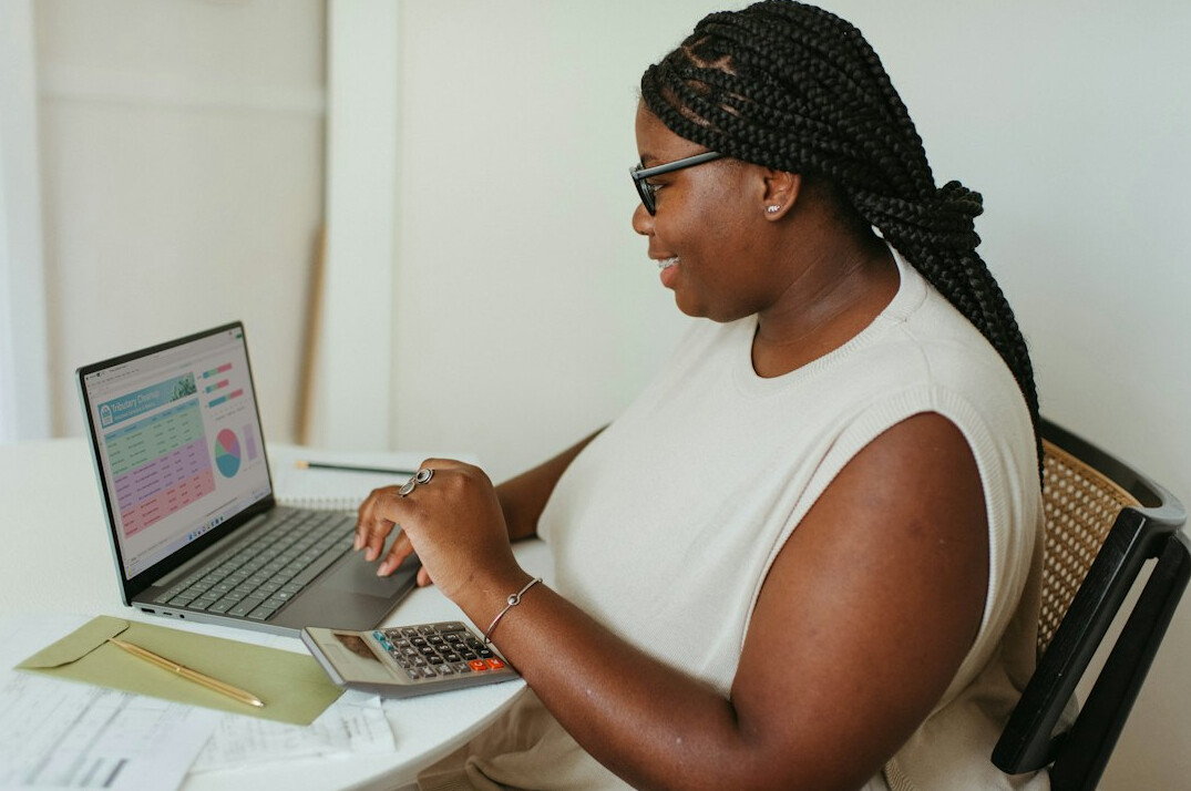 woman calculating expenses on laptop